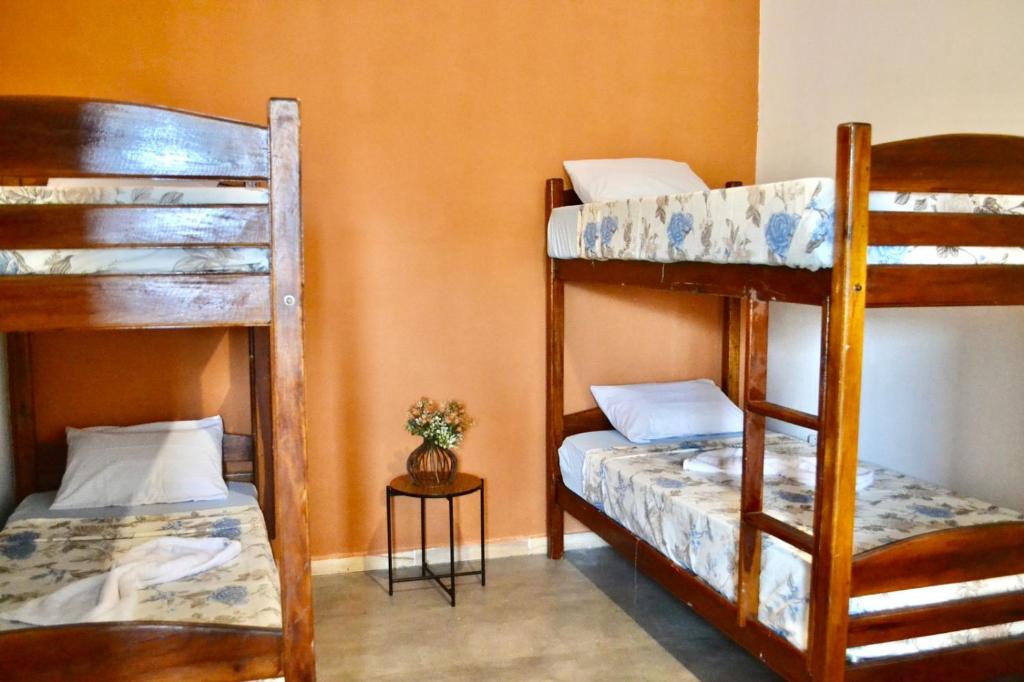 Zimmer mit 2 Etagenbetten und einem Tisch in der Unterkunft Villa Manga Rosa in Lençóis