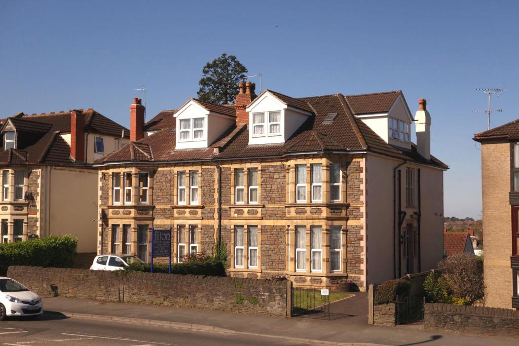 a large brick house with a car parked in front of it at Filton Guest House in Bristol