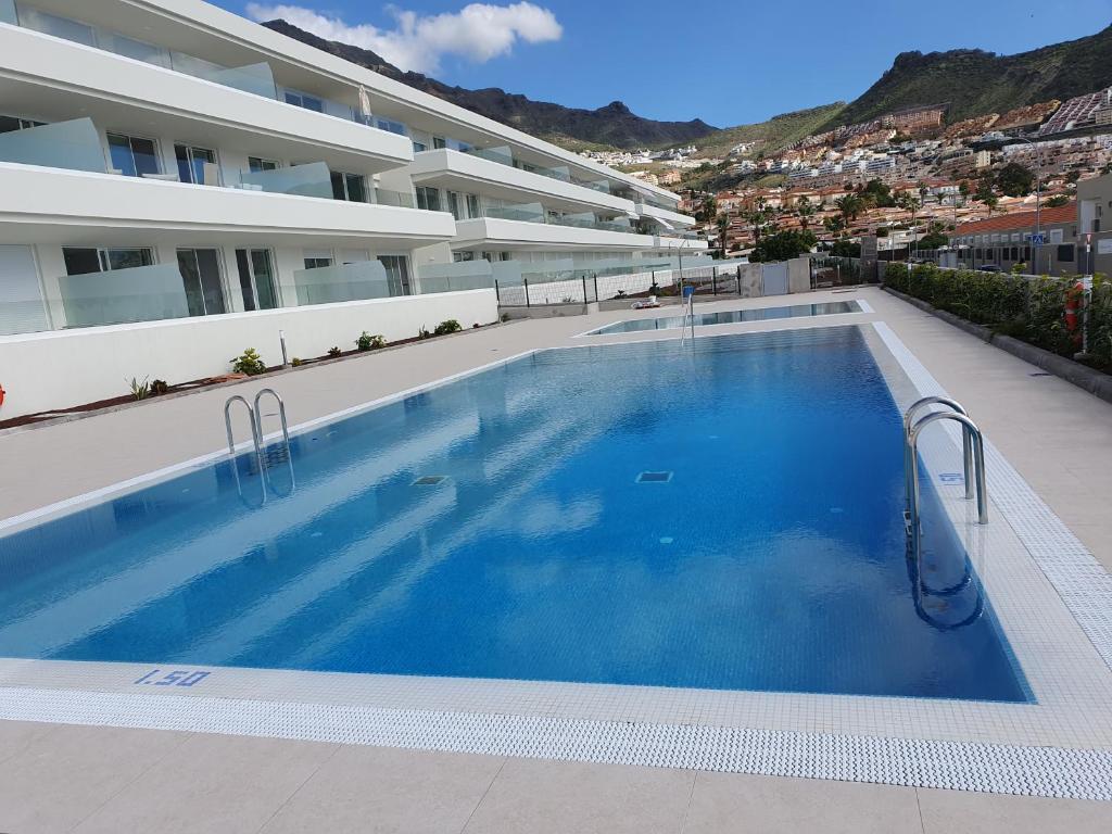 a large swimming pool in front of a building at Costa Adeje Ocean View Apartment in Adeje