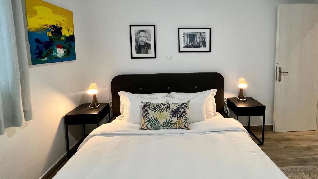 een slaapkamer met een wit bed en 2 nachtkastjes bij Mr Negri in Athene
