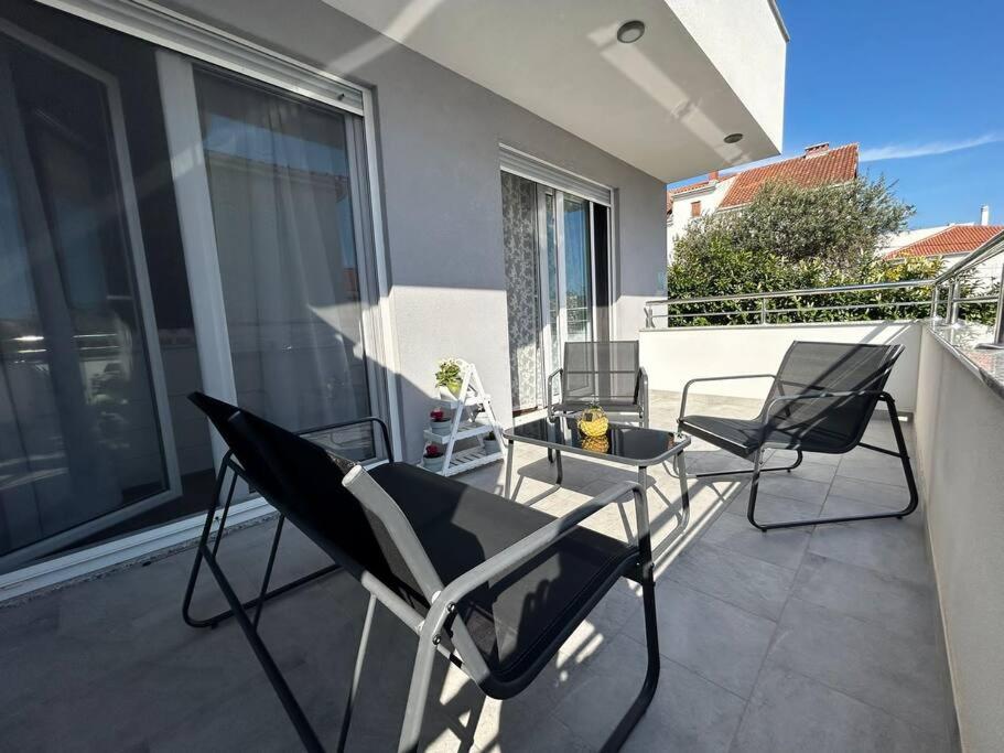 een patio met stoelen en een tafel op een balkon bij Apartment Adrian in Kaštela