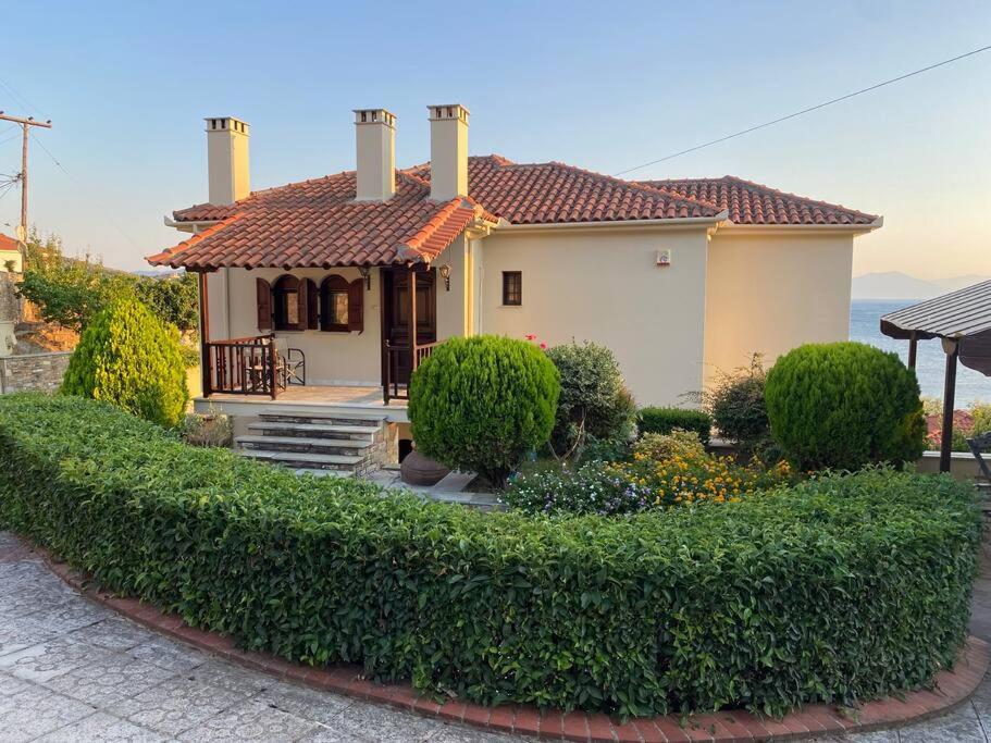 a house with a hedge in front of a house at La Grande Maison,Lefokastro in Afissos