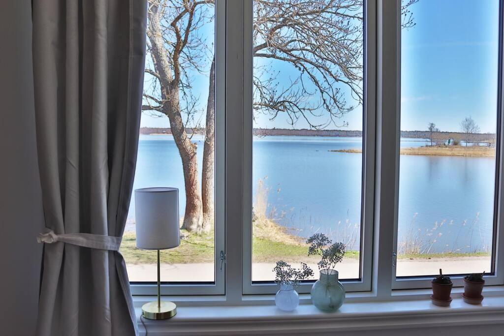 a window with a view of a body of water at Captivating Harbor View Suite in Östhammar