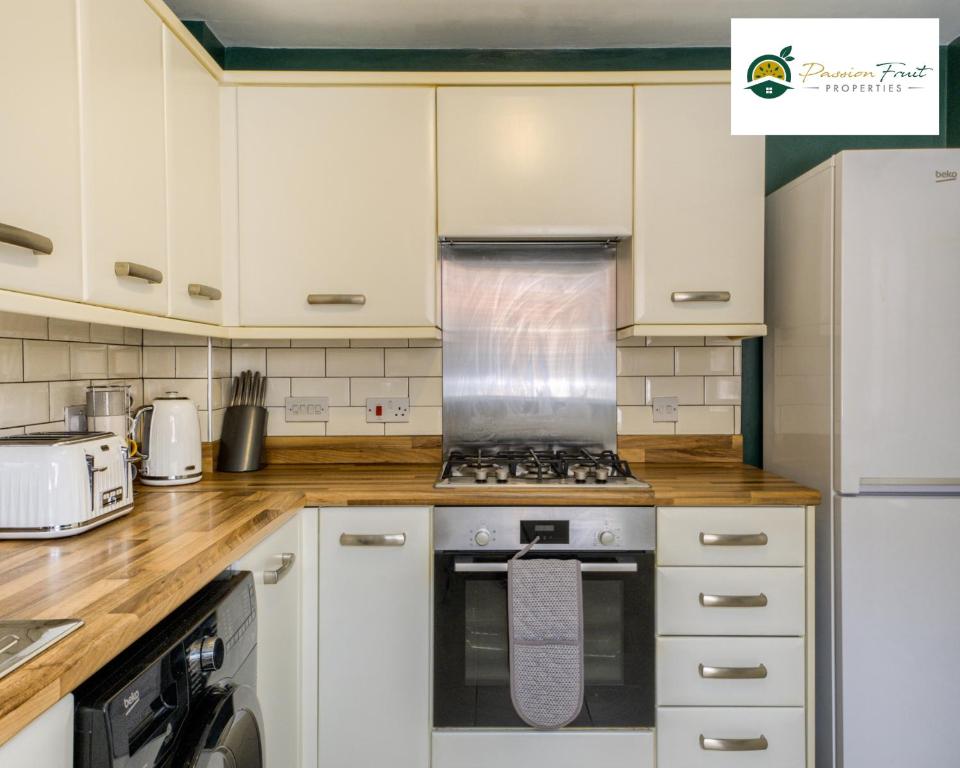 a kitchen with white cabinets and a stove top oven at LOW Price this winter 3 Bedroom House in Coventry - Sleeps 5 - With Free Unlimited Wi-fi, Driveway & Garden By Passionfruit Properties- 26WWC in Coventry