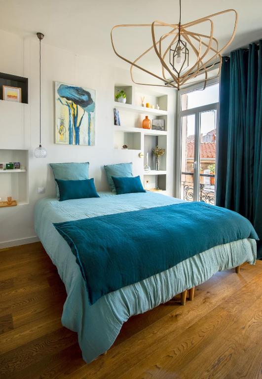 - un grand lit dans une chambre avec une couverture bleue dans l'établissement La Maison Vague - Guest House, à Marseille