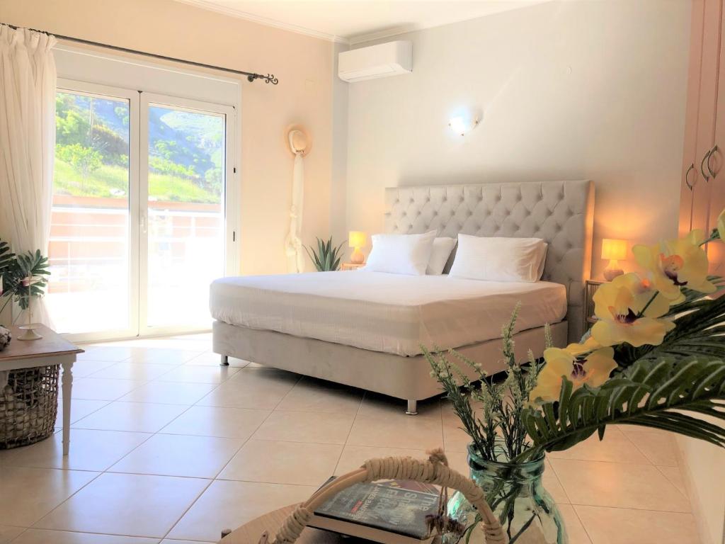 1 dormitorio con cama y ventana grande en Villa Aeolus with private overflow, endless, heated pool, en Prinés