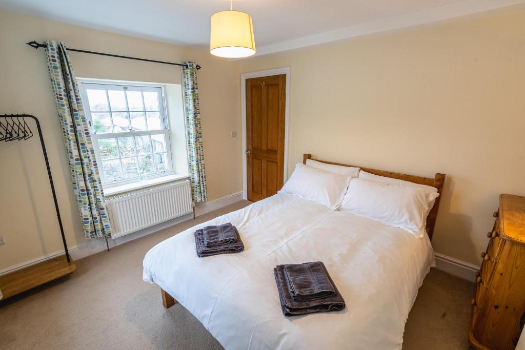 - une chambre avec un lit et 2 serviettes dans l'établissement Entire cottage & private garden in Scorton, à Scorton