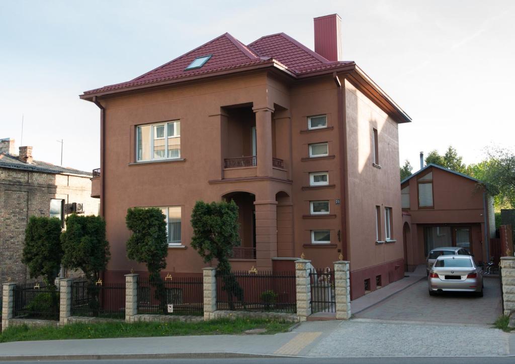 een bruin huis met een auto ervoor geparkeerd bij Petro delux apartments center in Kaunas