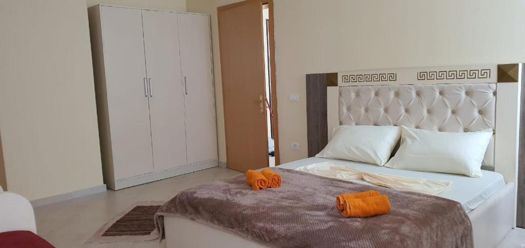 1 dormitorio con 1 cama con 2 almohadas de color naranja en Apartamenti 204, en Shëngjin