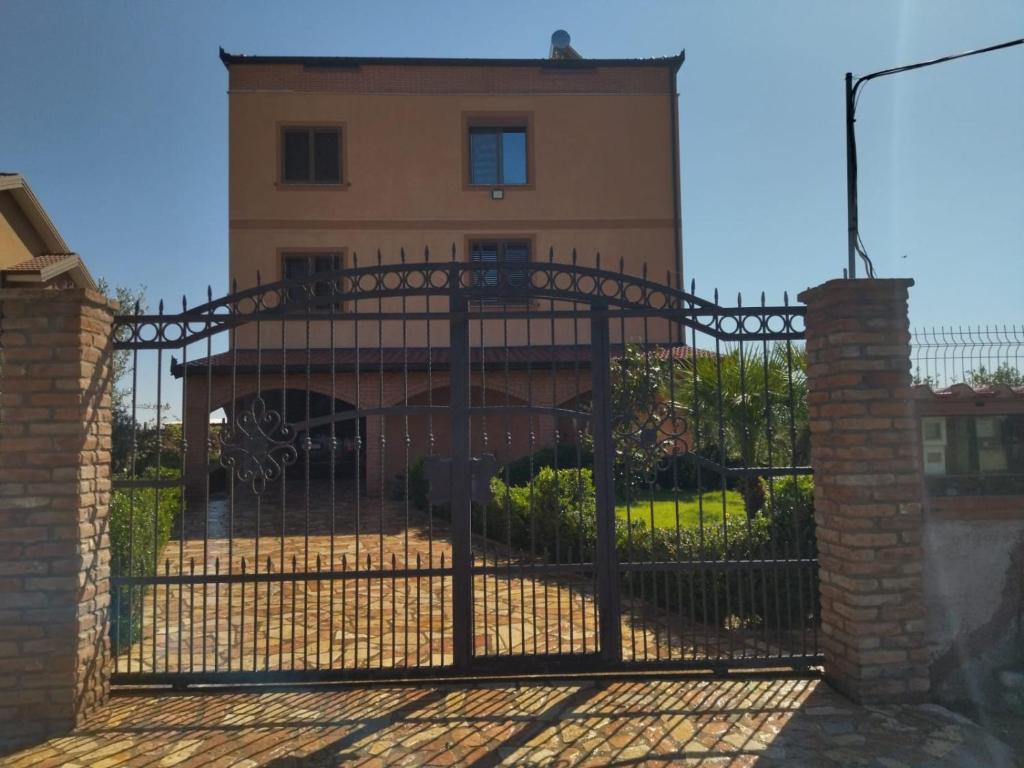 an iron gate in front of a house at The Garden Guest House in Divjakë