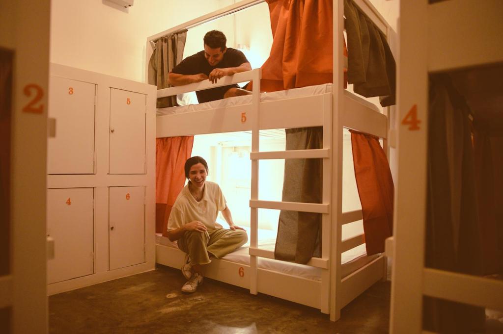 a woman sitting on the bottom bunk of a bunk bed at Macarena Hostel in Flores