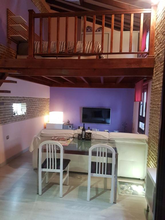 Zimmer mit einem Schreibtisch mit 2 Stühlen und einem TV in der Unterkunft COSY DOUBLE ROOM + PRIVATE BATHROOM SEVILLA CENTER in Sevilla