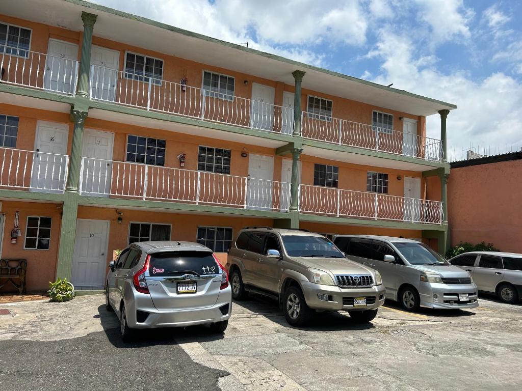 un grupo de coches estacionados frente a un edificio en Tropical Manor Inn - Kingston, en Kingston