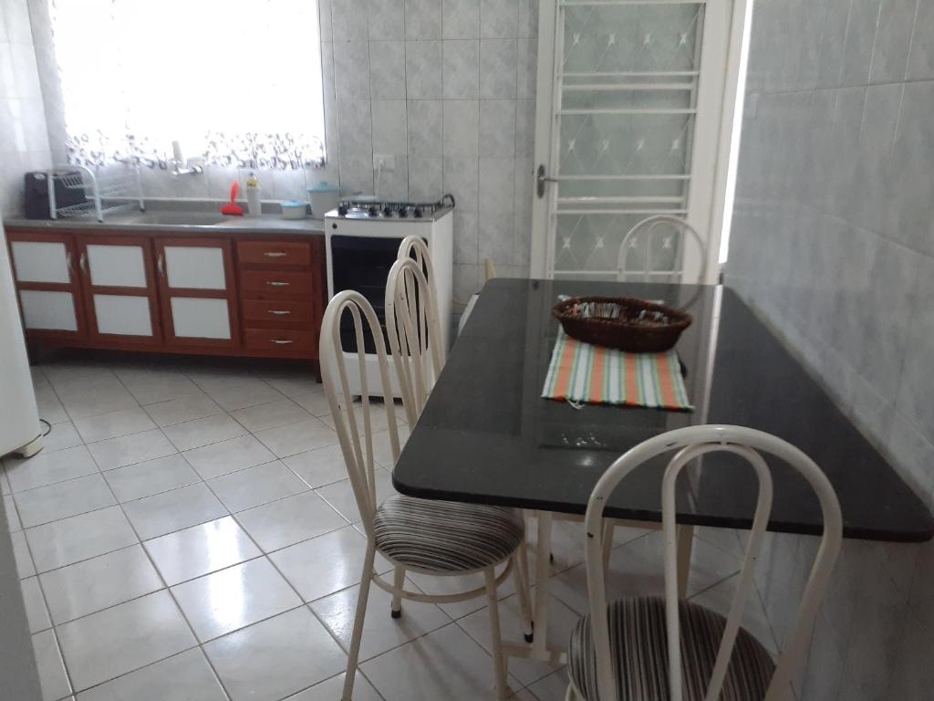 una cucina con tavolo, sedie e piano di lavoro di Casa Agradável próxima ao Bosque a Porto Feliz