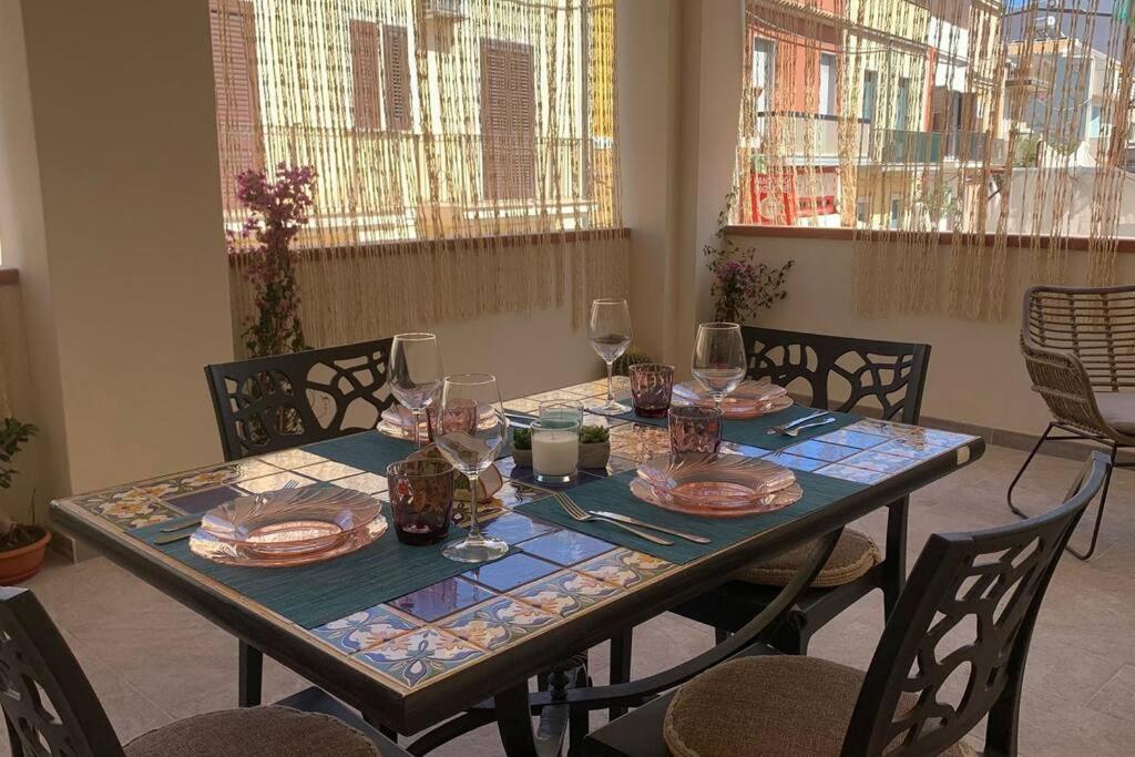 a table with plates and wine glasses on it at Casa Franca a Marzamemi in Marzamemi