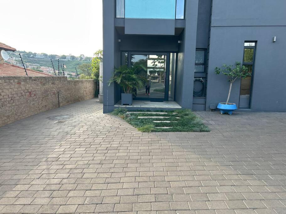 a building with a courtyard with potted plants in front of it at Waterkloof Nature Reserve Studio Apartment in Pretoria