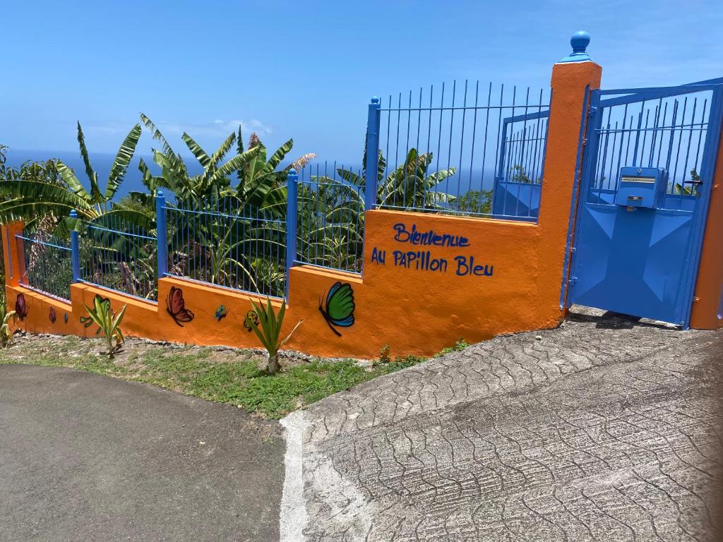 a gate with a sign that says no railway bat at Le Papillon Bleu in Bouillante