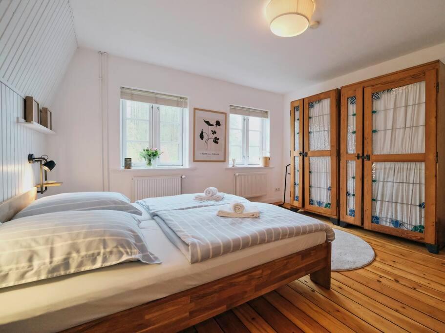 ein Schlafzimmer mit einem großen Bett in einem Zimmer mit Fenstern in der Unterkunft Koje 2 in Glücksburg