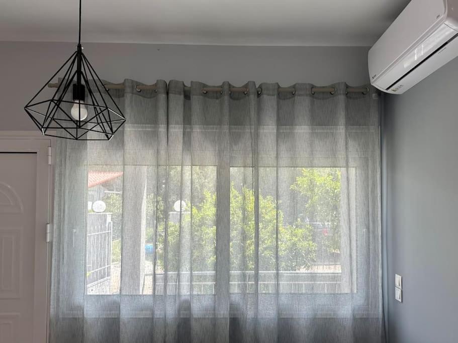 a window with a curtain in a room at Zouf house in Panayía Mesosporítissa