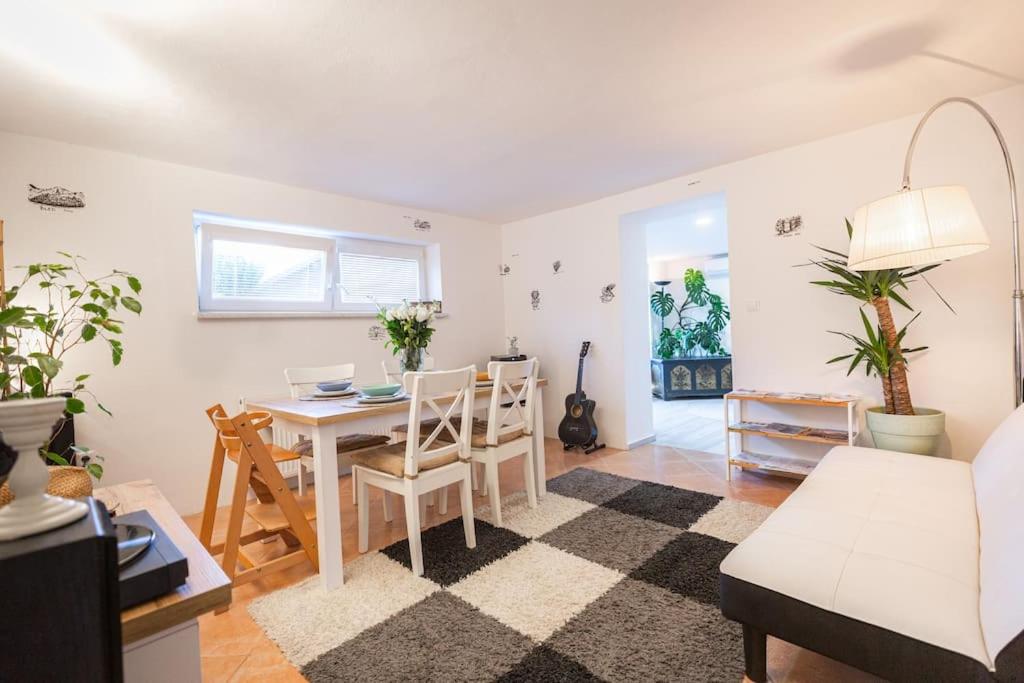 una sala de estar blanca con mesa y sillas en Family Home Stay Ma-Rich with Free Parking, en Liubliana