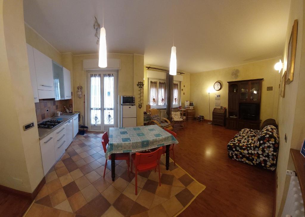 een keuken en een woonkamer met een tafel. bij ASTI LOVELY APARTMENT in Asti