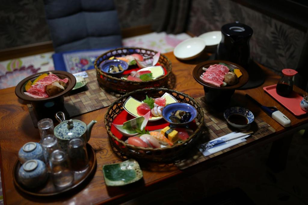 Shimosato的住宿－ゲストハウス れんげ苑，一张桌子上放着三篮子的食物