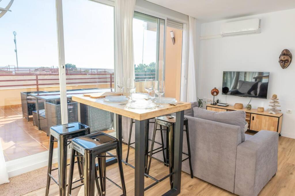 a kitchen and living room with a table and a couch at Apartamento Sereno 1 - Piscina, Garaje, Terraza y Playa in Los Caños de Meca