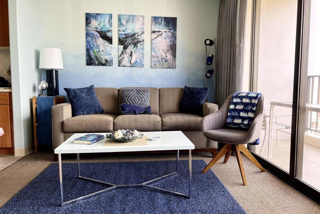 a living room with a couch and a table and a chair at The Whale Suite @Waikiki Banyan (1 Free Parking) in Honolulu