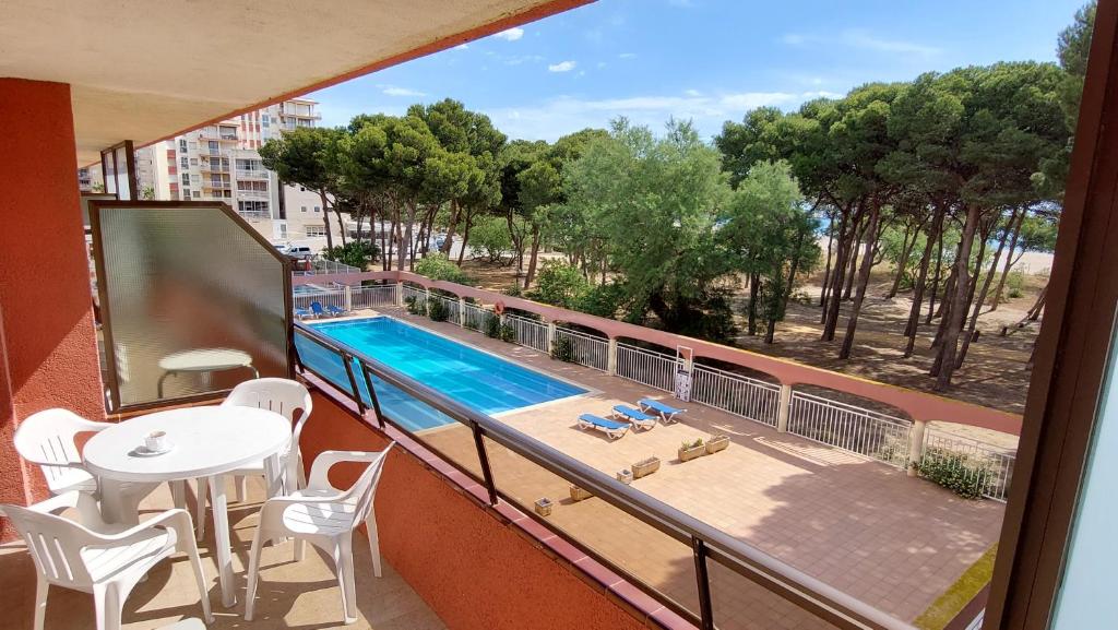 a balcony with a swimming pool and a table and chairs at Primera línea y vistas al mar con piscina in L'Estartit