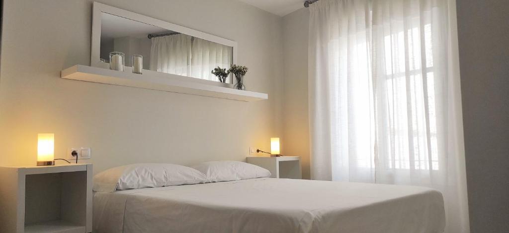 Habitación blanca con cama y ventana en Accommodation Campanario de la Magdalena en Córdoba