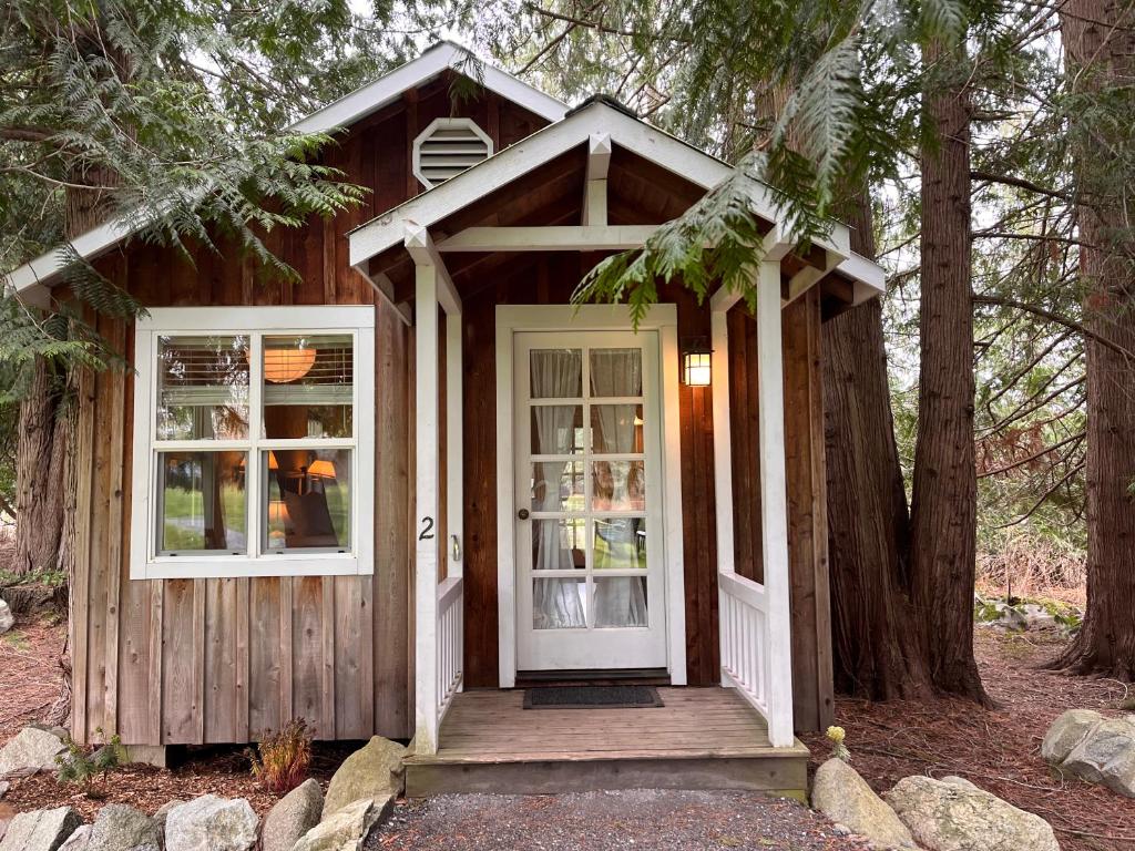 una casa pequeña con porche y puerta en Lopez Farm Cottages & Tent Camping, en Lopez