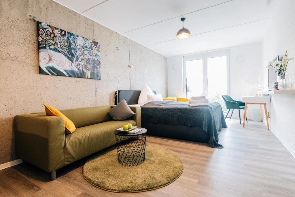 a living room with a couch and a bed at City-Living Appartement in Bielefeld