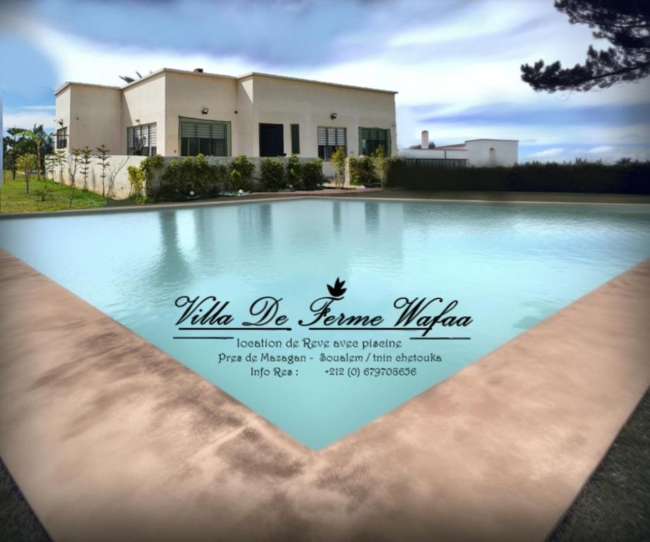 a picture of a house with a swimming pool at Villa de Ferme Wafaa - Location de Rêve avec Piscine près de Mazagan in El Jadida