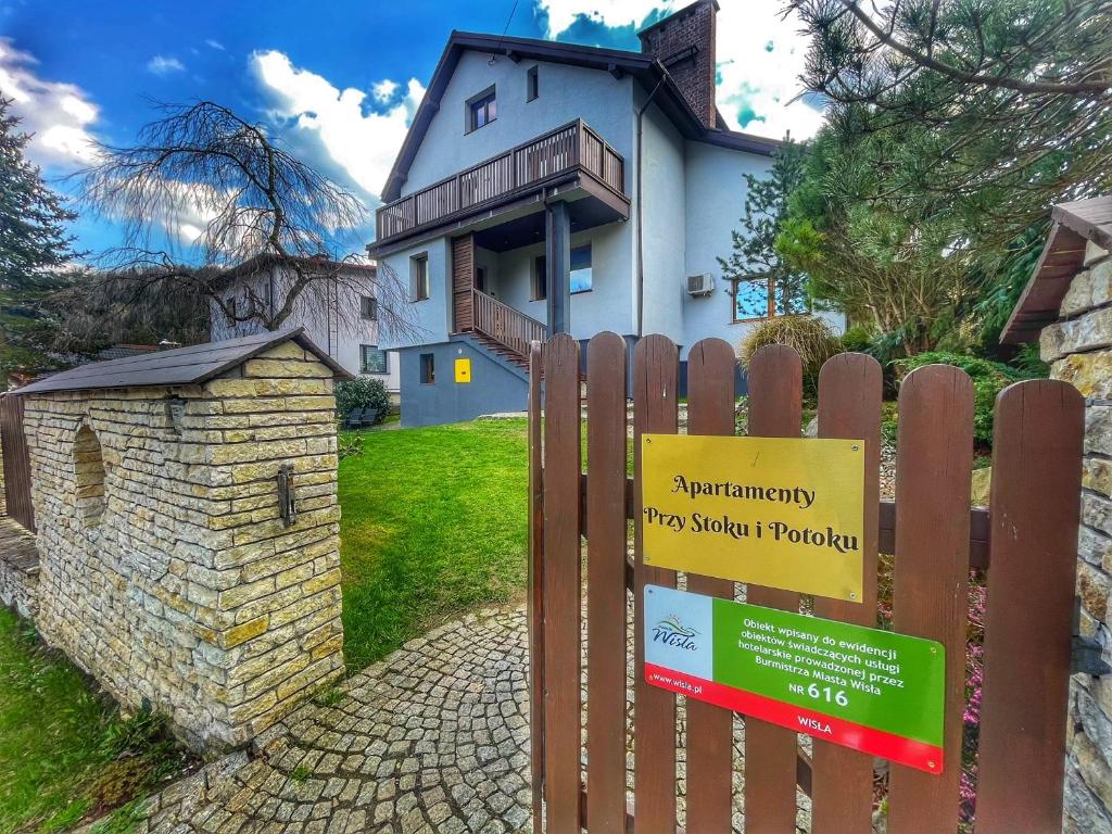 ein Schild auf einem Zaun vor einem Haus in der Unterkunft Przy Stoku i Potoku in Wisła