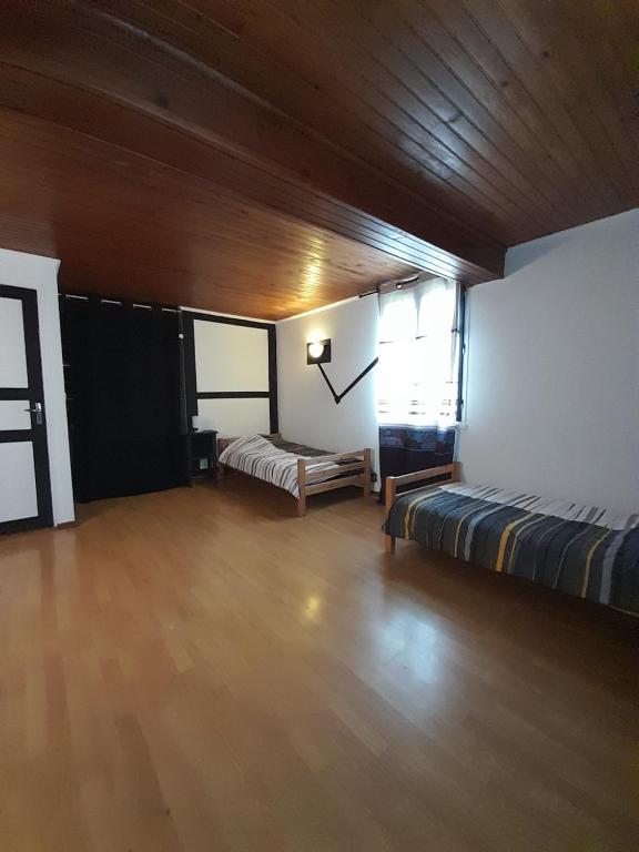 Großes Zimmer mit 2 Betten und einer Holzdecke. in der Unterkunft Maison dans le sud du Gers 