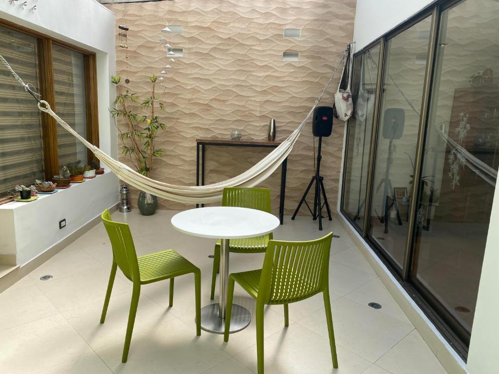 una mesa con sillas y una hamaca en una habitación en CHARLIE'S HOUSE en Bogotá