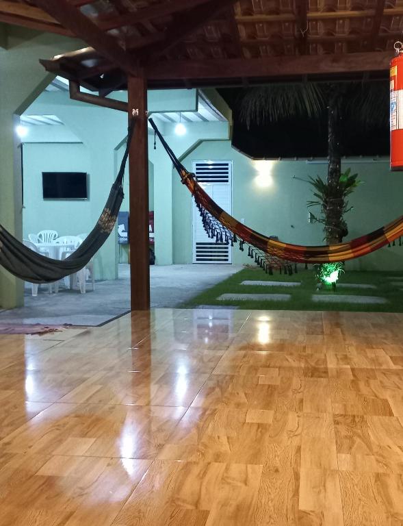 a hammock in a room with a wooden floor at Pousada Cantinho da Mata in Paraty