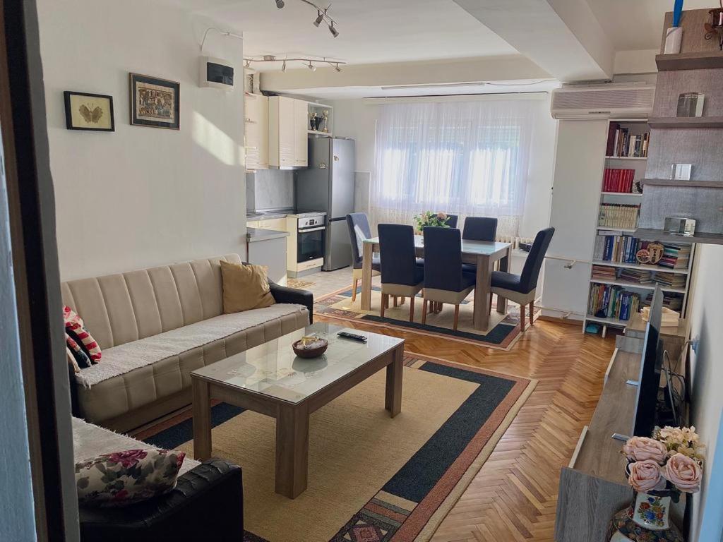 uma sala de estar com um sofá e uma mesa em Rooftop terrace appartment em Skopje