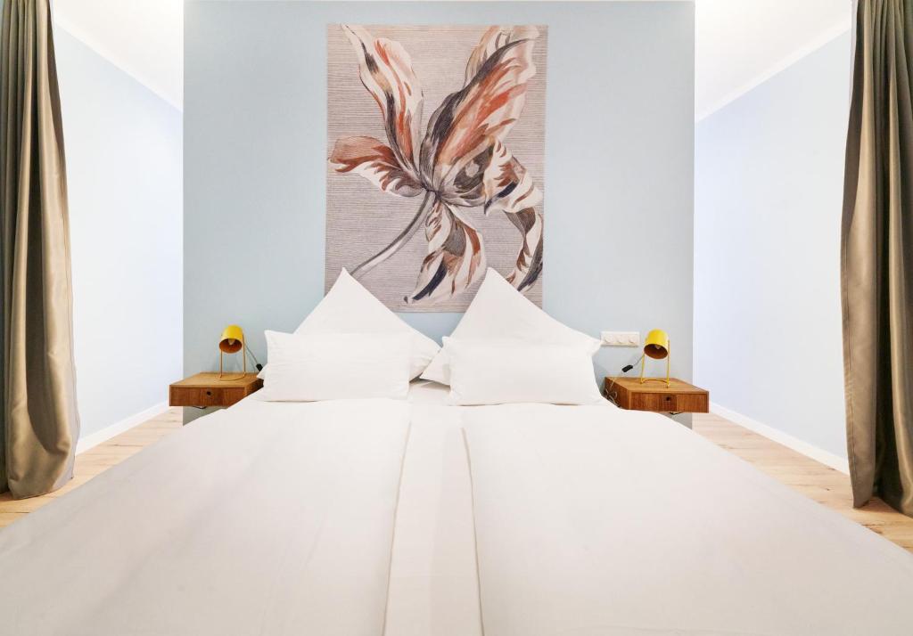 a white bed with white pillows in a bedroom at Design Studio I 3 Personen I Innenstadt I Küche I WIFI in Bingen am Rhein