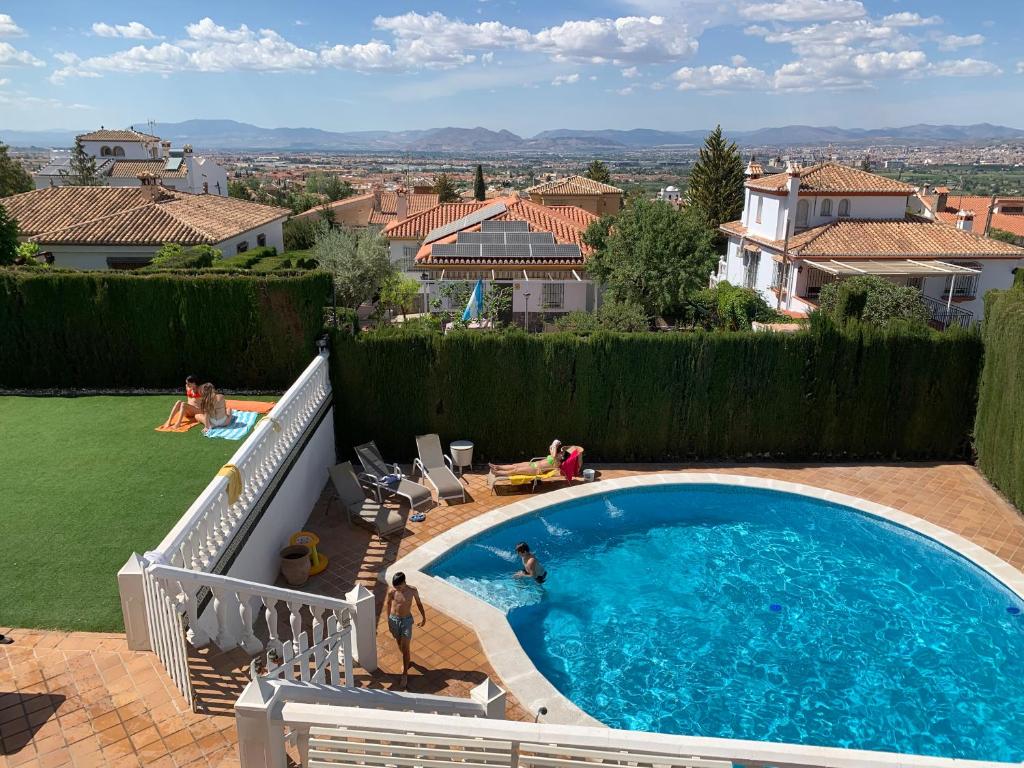 une grande piscine avec des personnes dans une cour dans l'établissement Villa Mare a los pies de Sierra Nevada, à Grenade