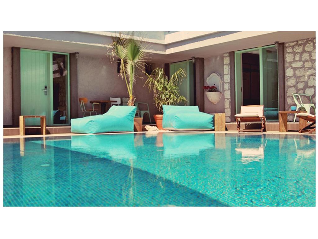 a large swimming pool with blue pillows and furniture at Brera Alacati - Special Category in Alaçatı