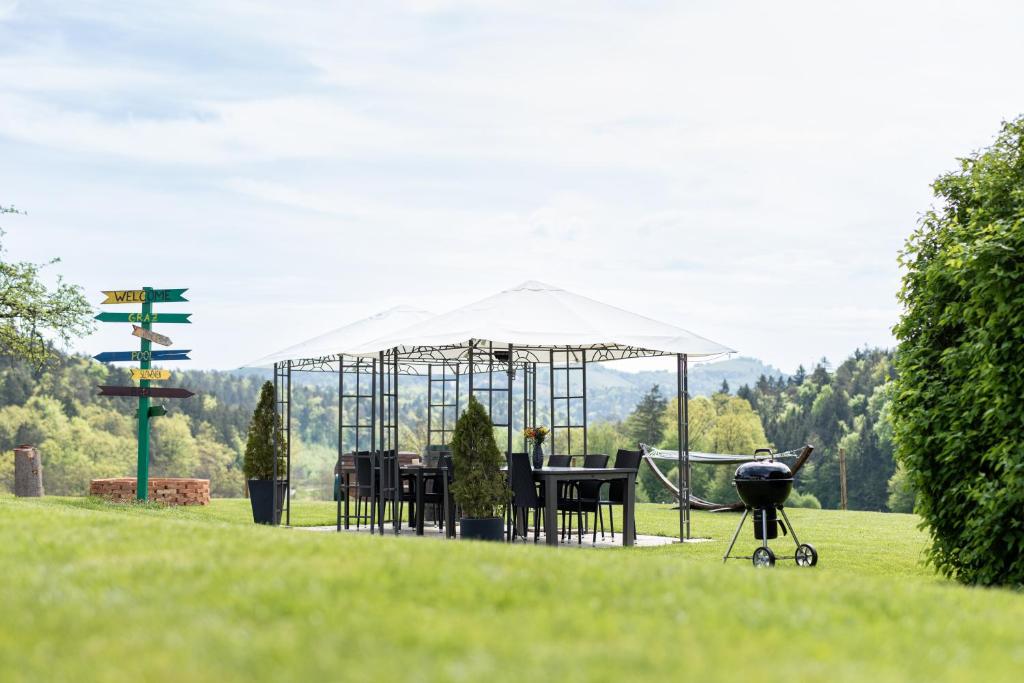 a gazebo with chairs and a grill in a field at ❤Einzigartiges HOF-AREAL Südsteiermark❤ in Sankt Nikolai im Sausal