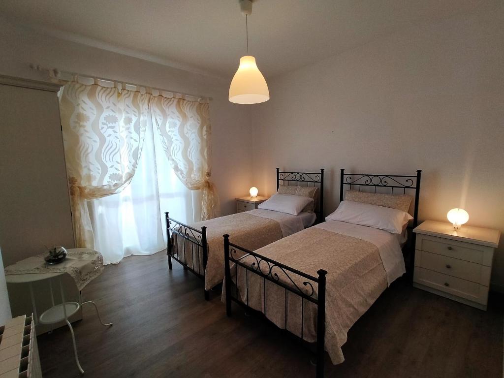 een slaapkamer met 2 bedden en een raam bij stella marina in Porto Recanati