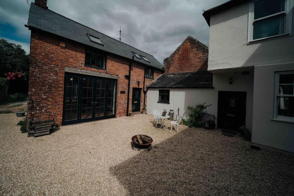 a courtyard of a brick building with a dog bed at Roxie House a cosy farm refurbished Coach House. in Gittisham