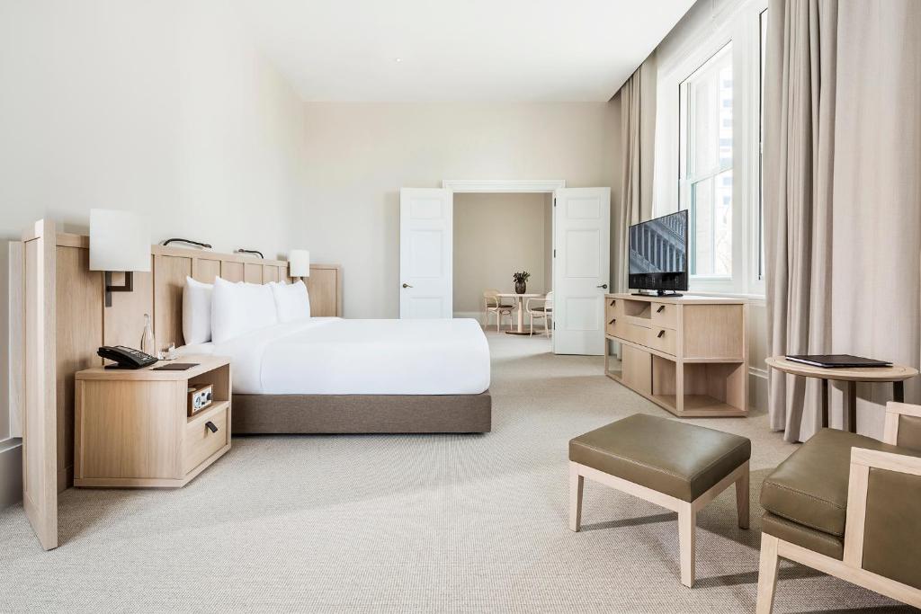 a hotel room with a bed and a television at COMO The Treasury in Perth