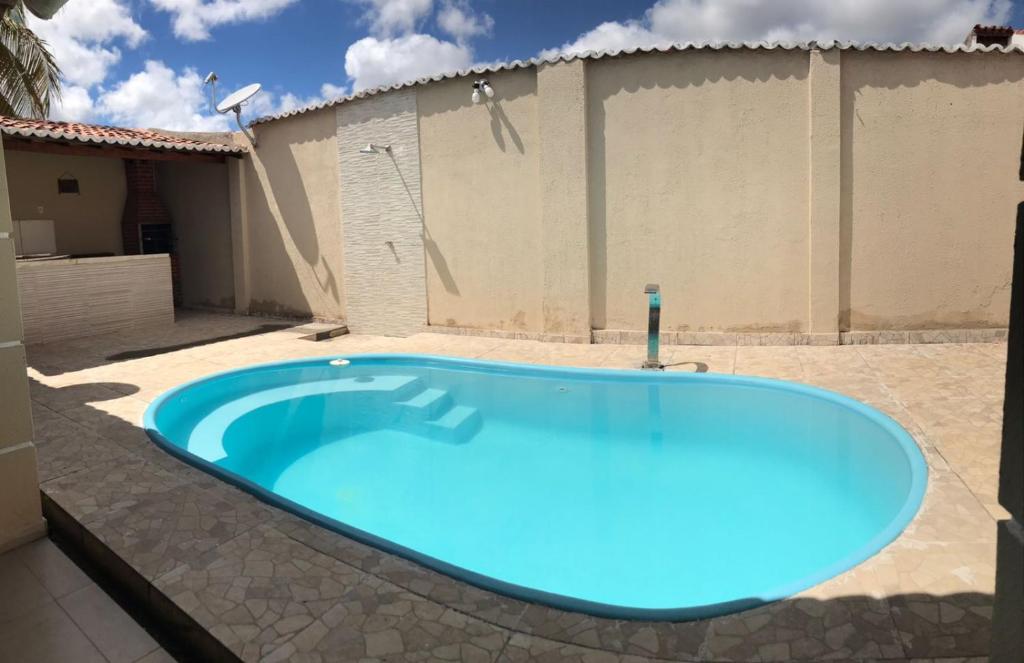 una gran piscina azul en el patio trasero de una casa en Propriedade sinta-se em casa en Piranhas