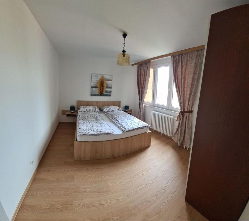 a bedroom with two beds and a window at Bilino polje in Zenica