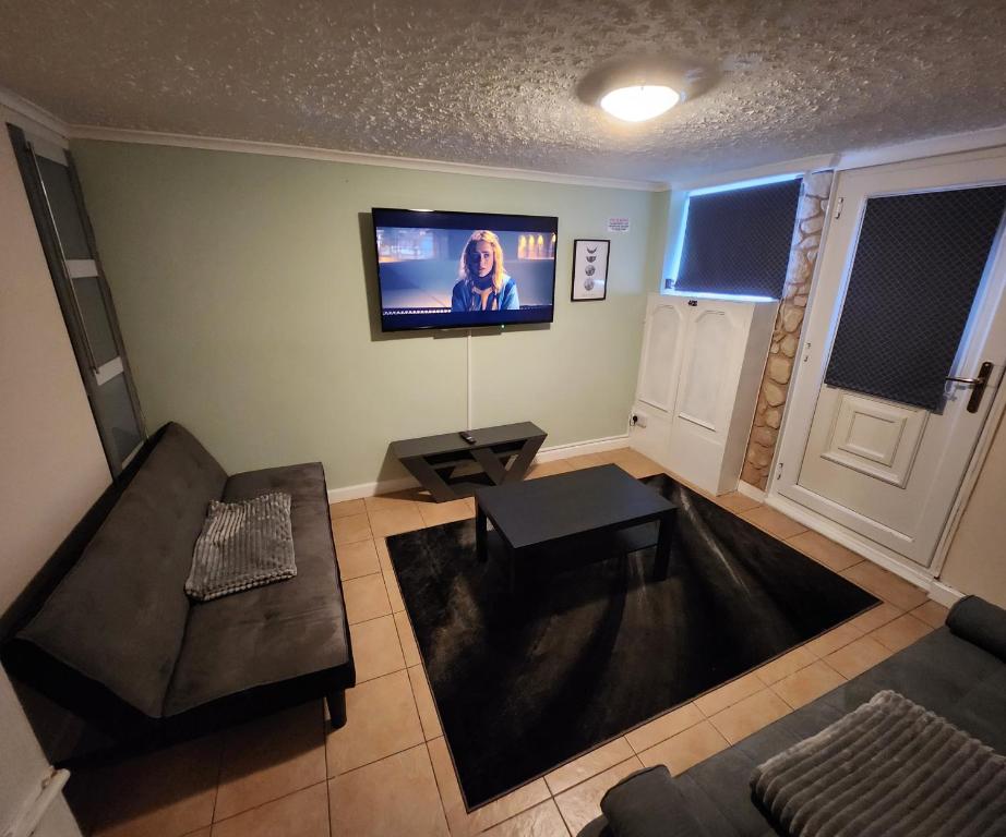 a living room with a couch and a tv on the wall at Maidstone castle 3bedroom free sports channels, parking in Kent
