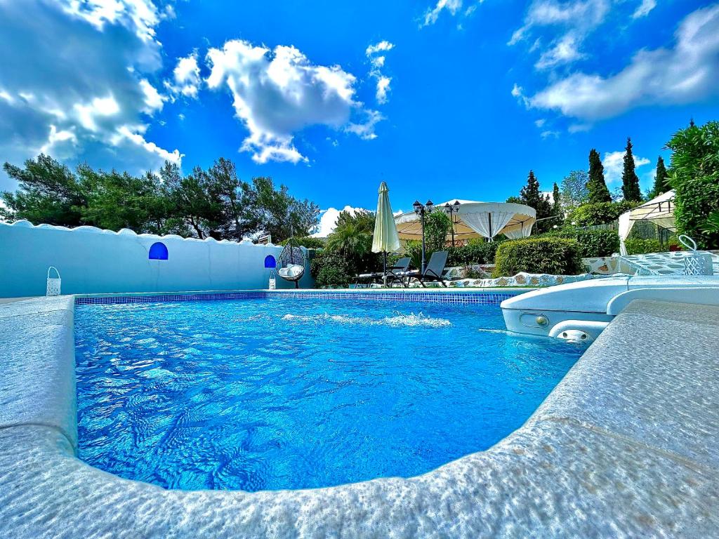 a swimming pool with blue water in a yard at Nicole Luxury Villas in Koskinou