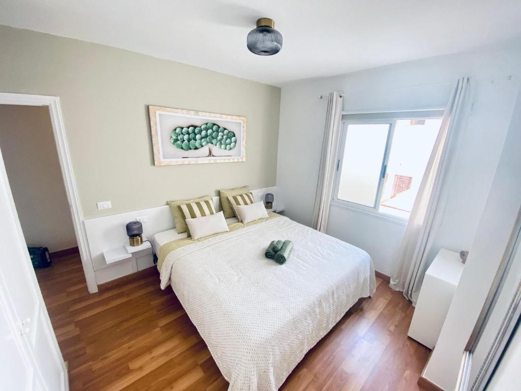 1 dormitorio con cama blanca y ventana en MÉDANO LOVER By TOP STAY, en El Médano